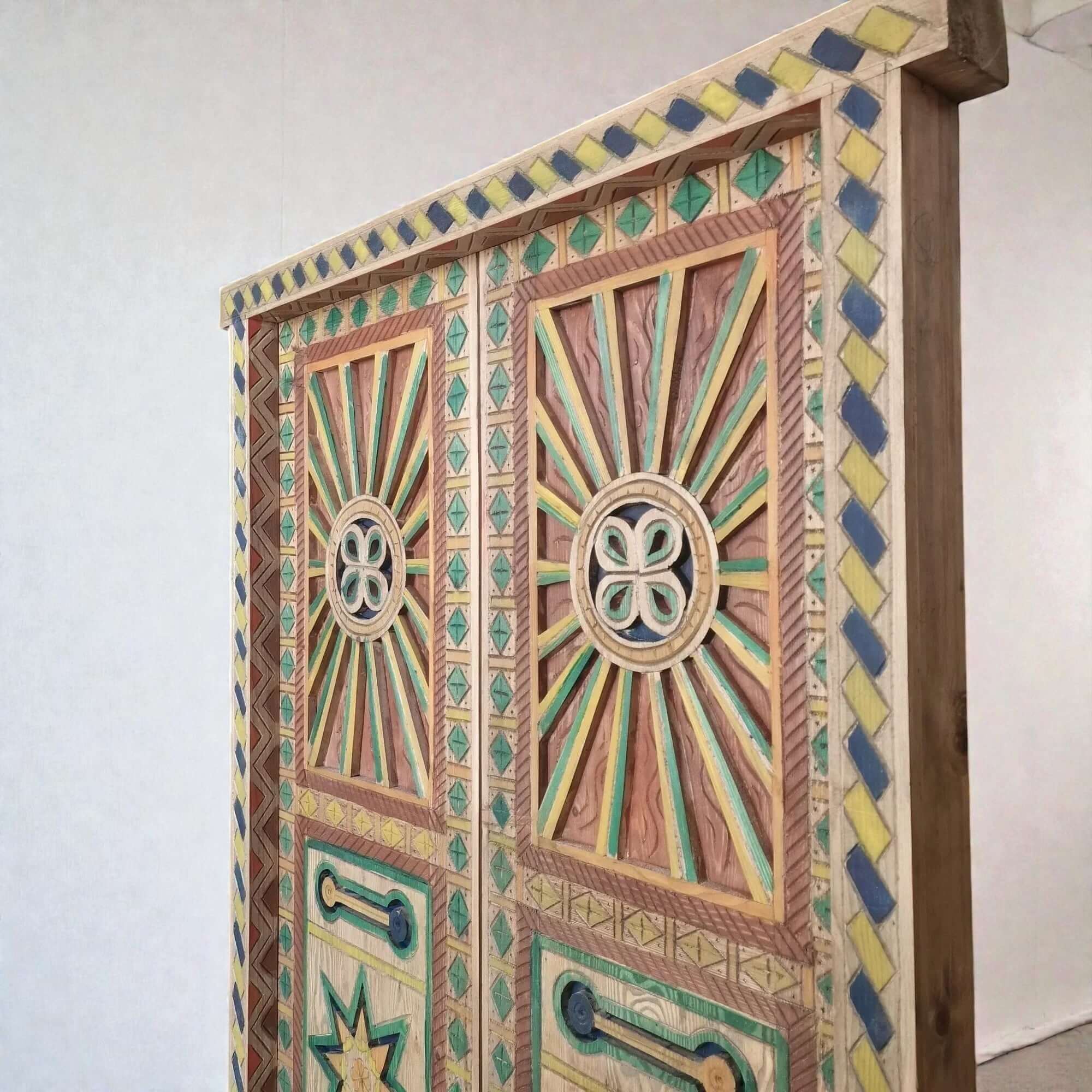 AtlasMuseCrafts multicolor hand-painted wood Moroccan door with geometric carving and sunburst motif.