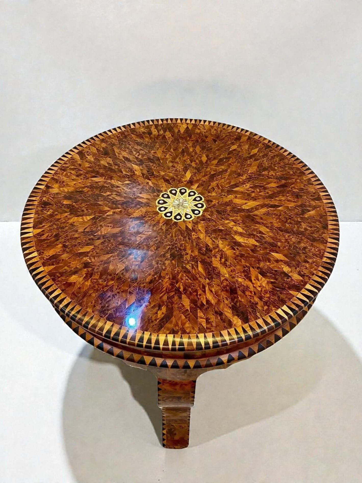 AtlasMuseCrafts handmade Moroccan Thuya wood coffee table with intricate inlaid geometric pattern and central floral inlay.