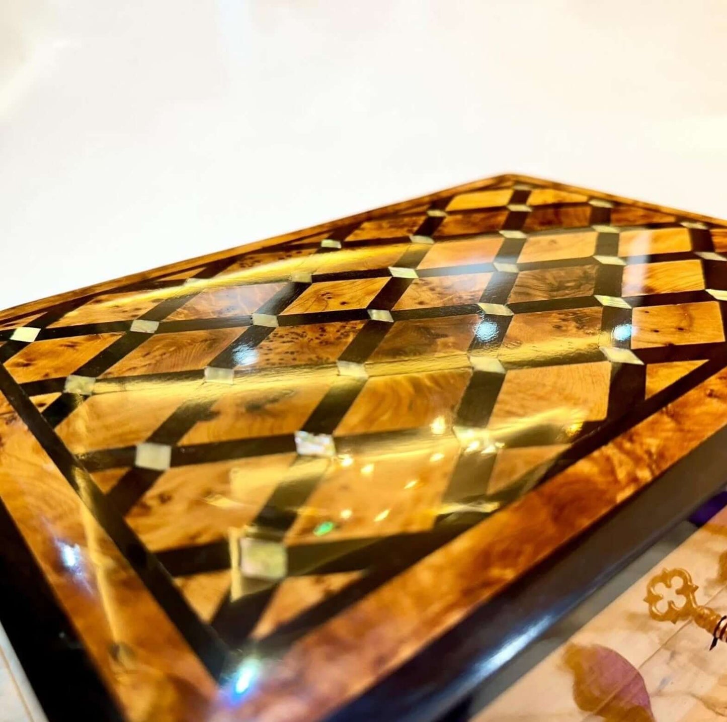 AtlasMuseCrafts handmade Moroccan Thuya wood jewelry box with polished amber burl grain and geometric inlay details.