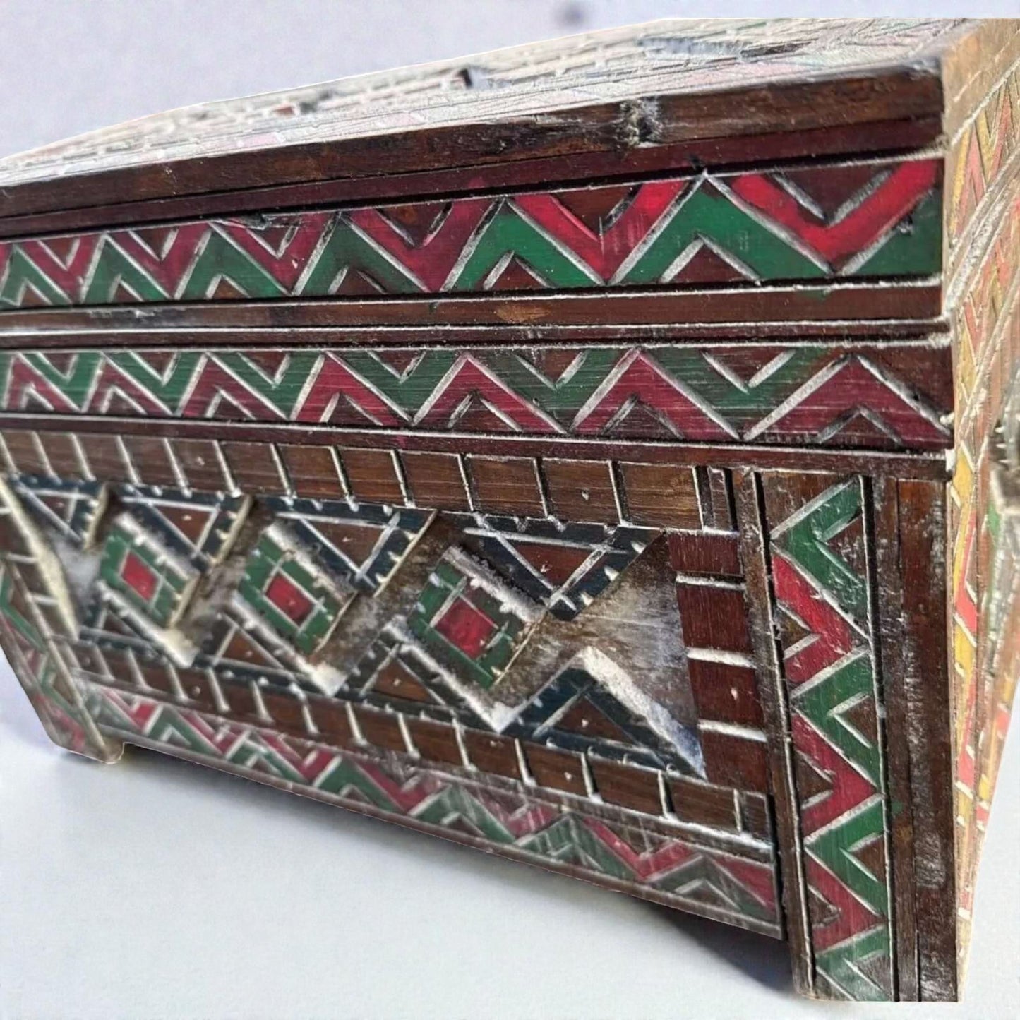 AtlasMuseCrafts custom Moroccan wood cabinet with hand-carved Berber patterns in red, green, and natural wood finish.
