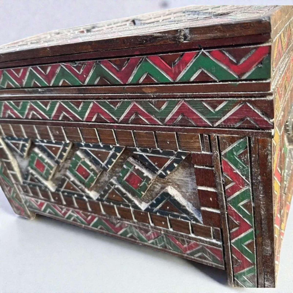 AtlasMuseCrafts custom Moroccan wood cabinet with hand-carved Berber patterns in red, green, and natural wood finish.