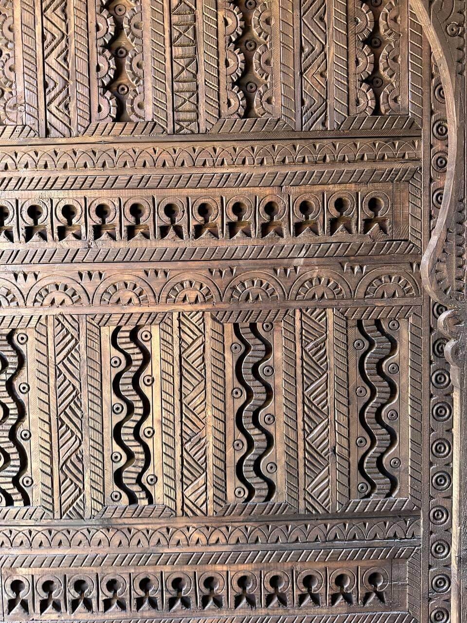 AtlasMuseCrafts custom Moroccan handmade wood door with intricate geometric carvings in natural wood finish.