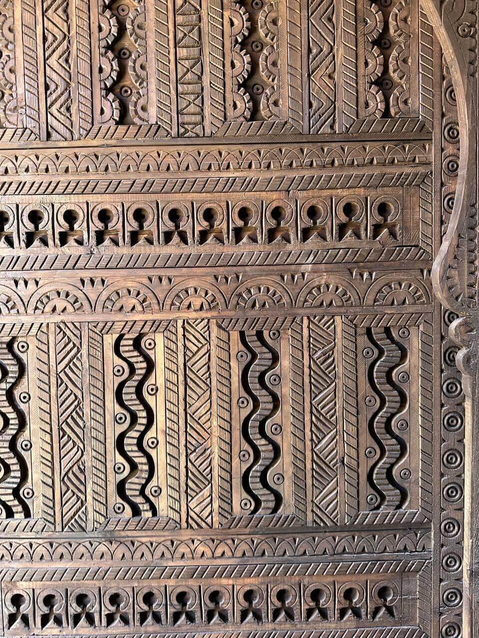 AtlasMuseCrafts custom Moroccan handmade wood door with intricate geometric carvings in natural wood finish.