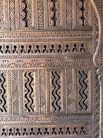 AtlasMuseCrafts custom Moroccan handmade wood door with intricate geometric carvings in natural wood finish.