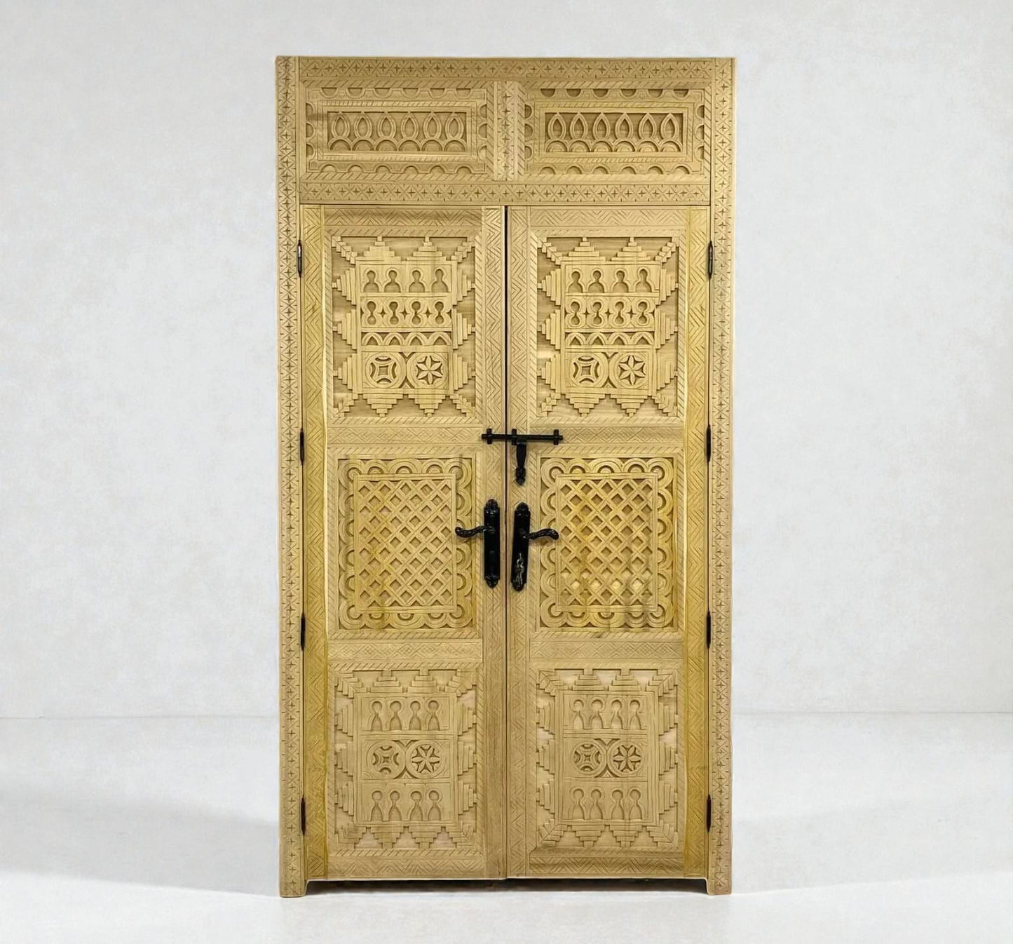 AtlasMuseCrafts natural wood double door with intricate Berber geometric carvings and black hardware.