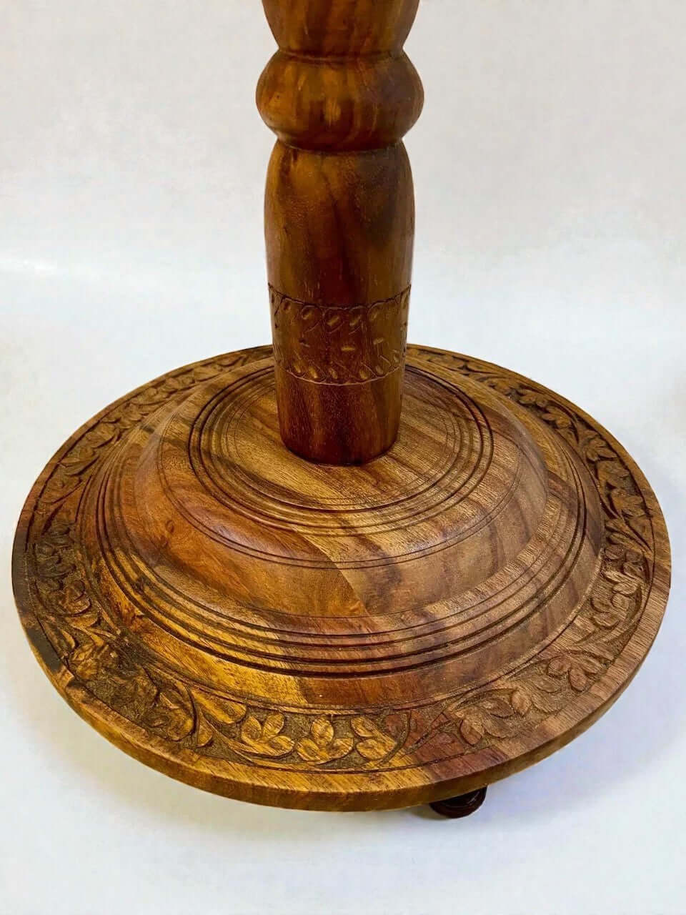Walnut coffee table with carved base and turned pedestal