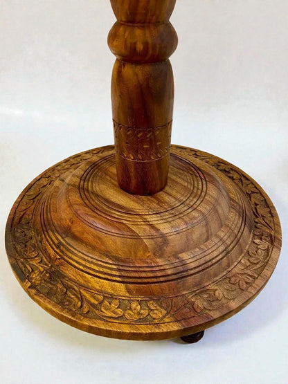 AtlasMuseCrafts handmade solid walnut coffee table with intricate carved base and turned pedestal. Rich natural wood grain.