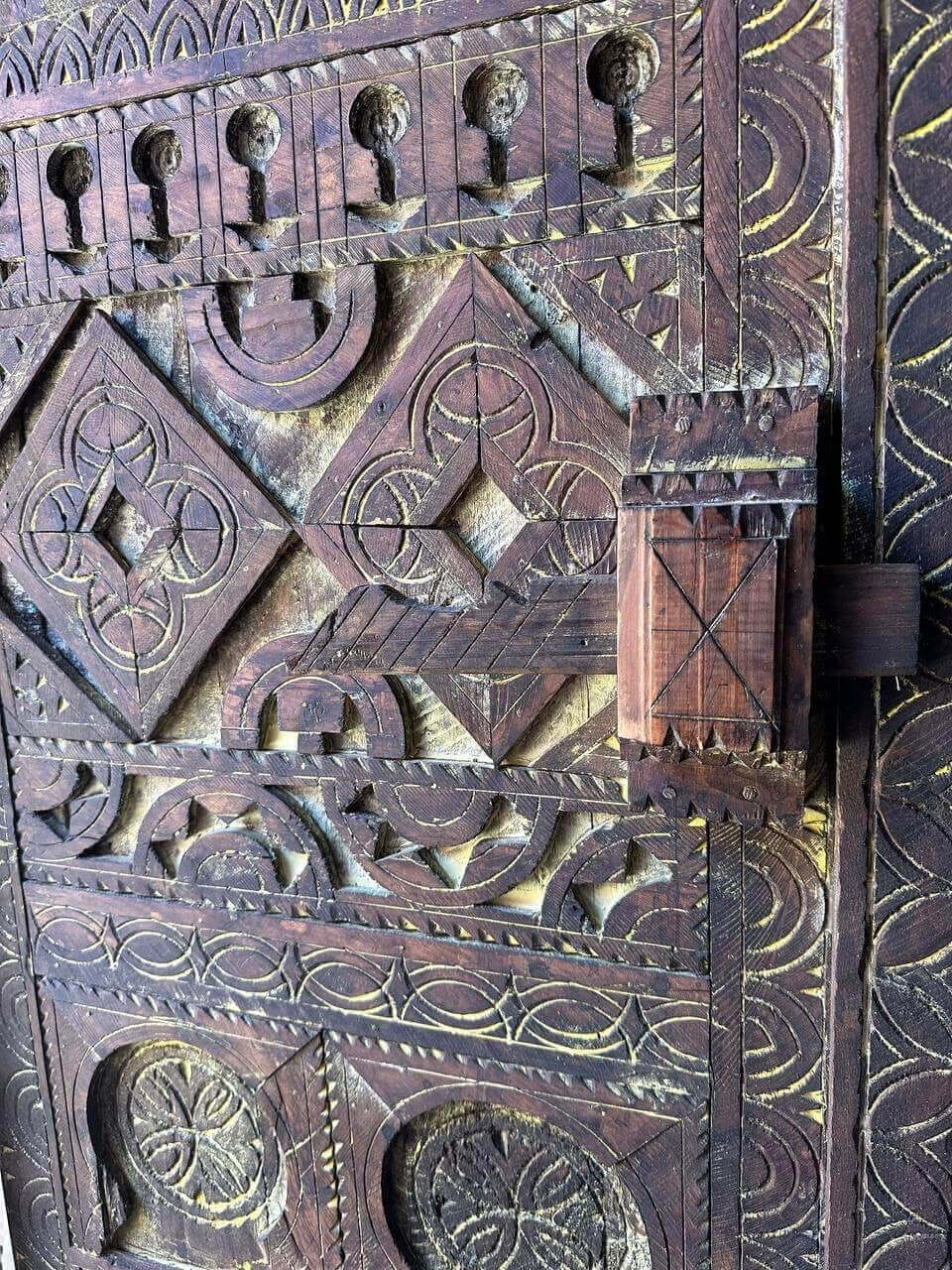 AtlasMuseCrafts vintage wooden door with intricate floral carvings and an antique brass knob. Natural wood finish.