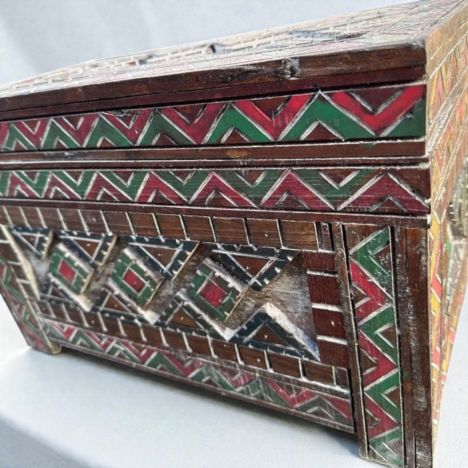 AtlasMuseCrafts handmade wooden cabinet with intricate carved Berber patterns in red, green, and white. Rustic boho style storage.