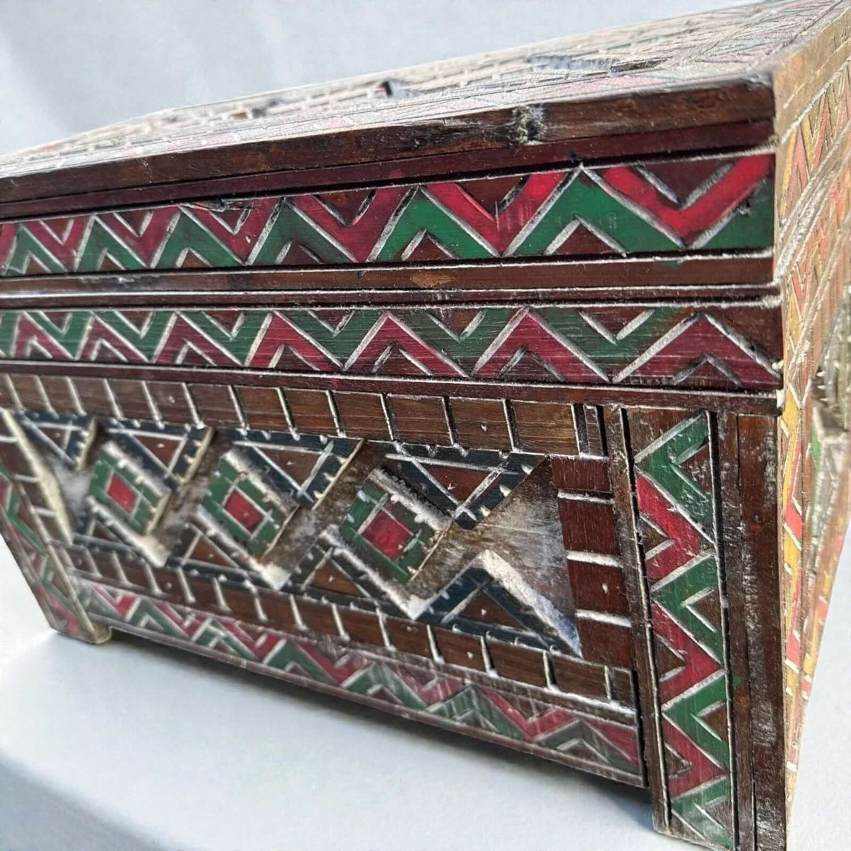 AtlasMuseCrafts handmade wooden cabinet with intricate carved Berber patterns in red, green, and white. Rustic boho style storage.