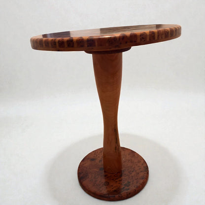 AtlasMuseCrafts handmade round solid wood coffee table with a tapered pedestal base and a natural wood finish.