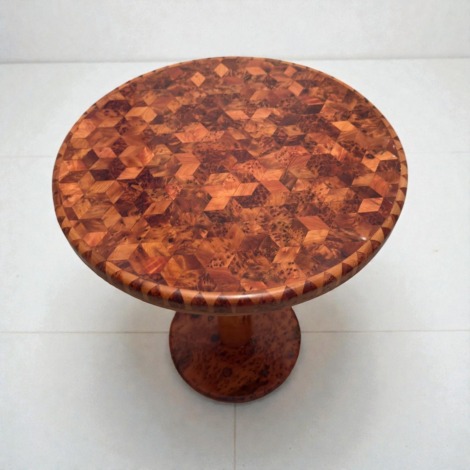 AtlasMuseCrafts handmade round solid wood coffee table with intricate geometric wood inlay pattern and pedestal base.