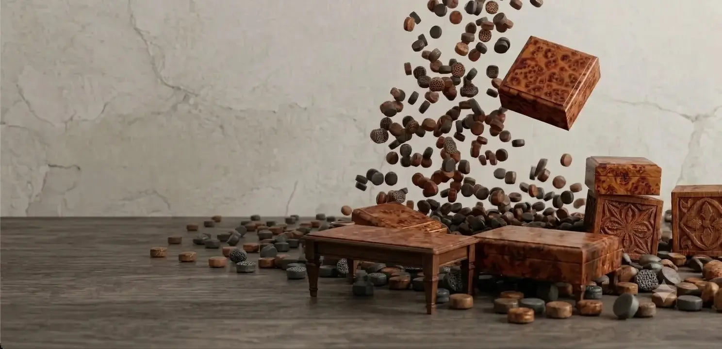 Decorative carved wooden blocks and small stone-like pieces arranged on a dark tabletop against a light textured wall, with many brown pieces floating in midair above the arrangement.