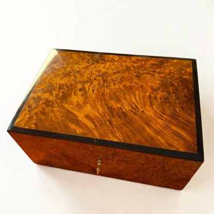 Thuya burl wood jewelry box with polished amber grain and dark trim