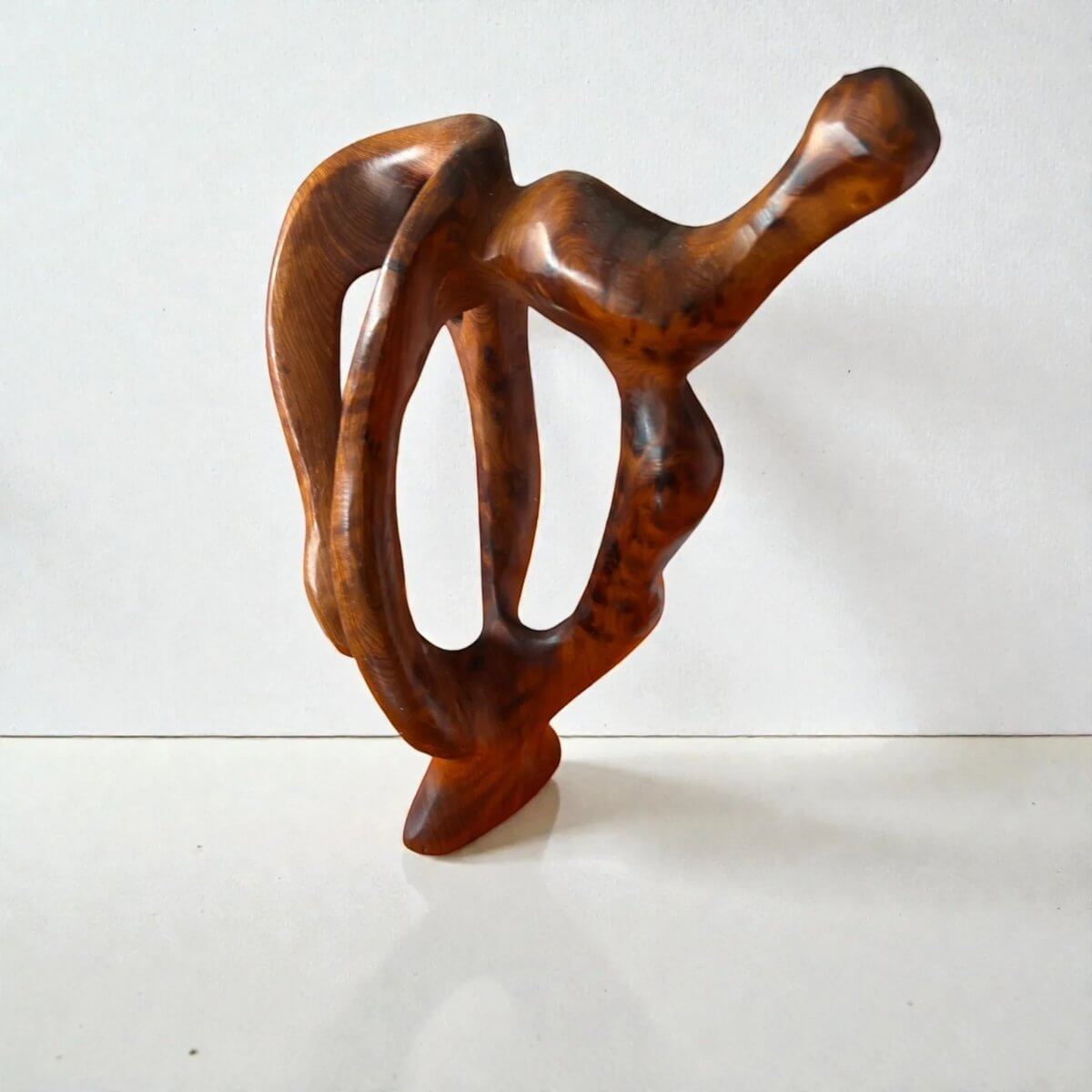 Contemporary wooden sculpture with flowing lines and warm grain
