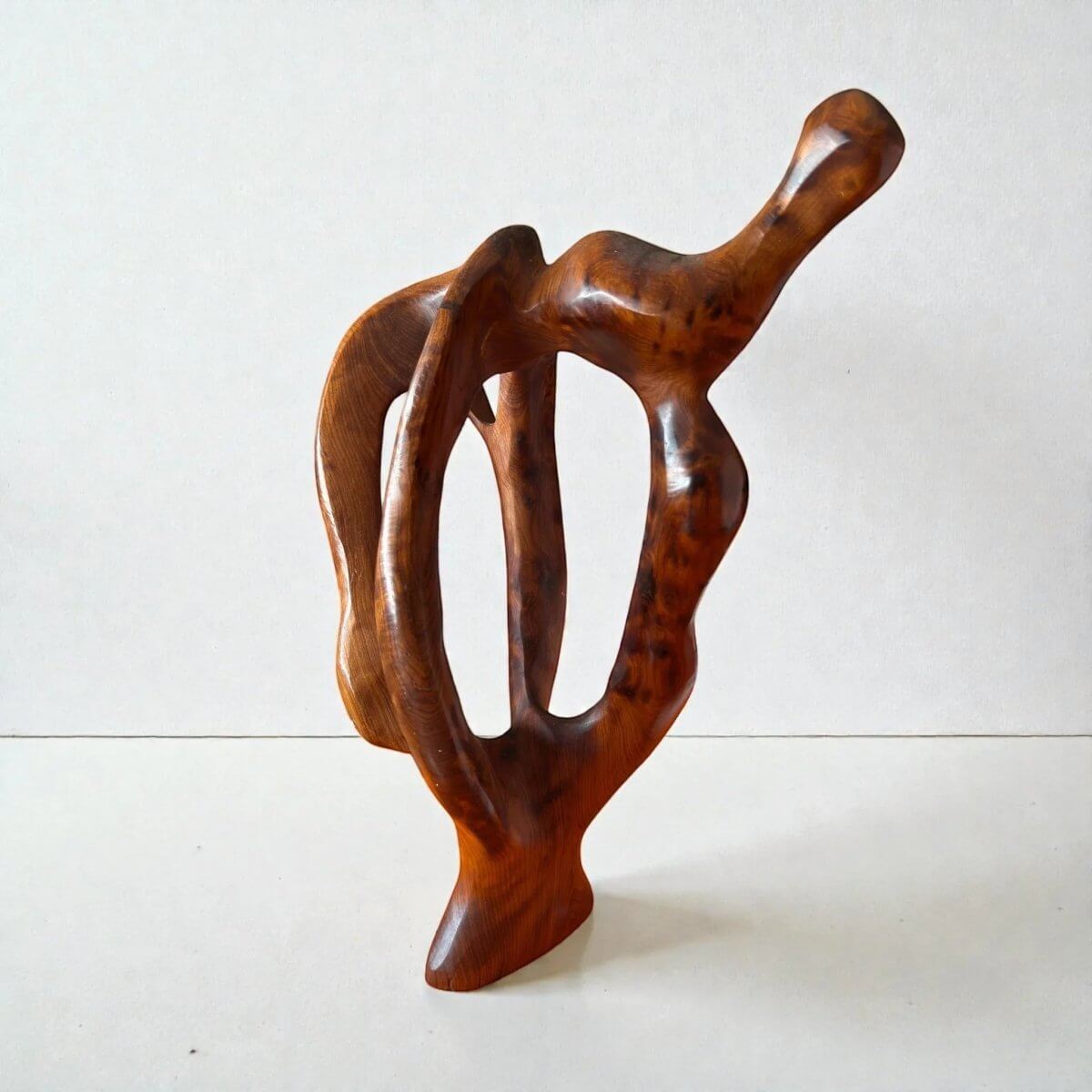 AtlasMuseCrafts handmade abstract wood sculpture with a polished, natural finish. Features organic curves and open spaces, ideal for modern decor.