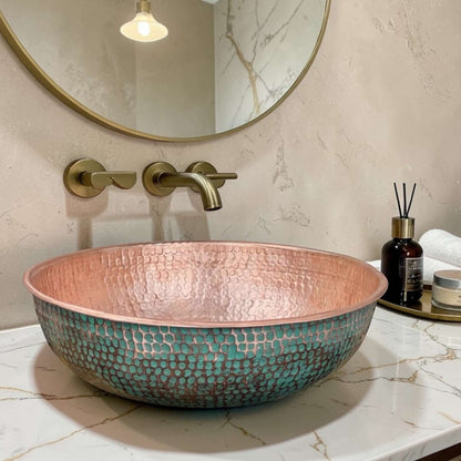 Green Patina Brass Vessel Sink with unique hammered texture and copper interior, displayed in modern bathroom setting.