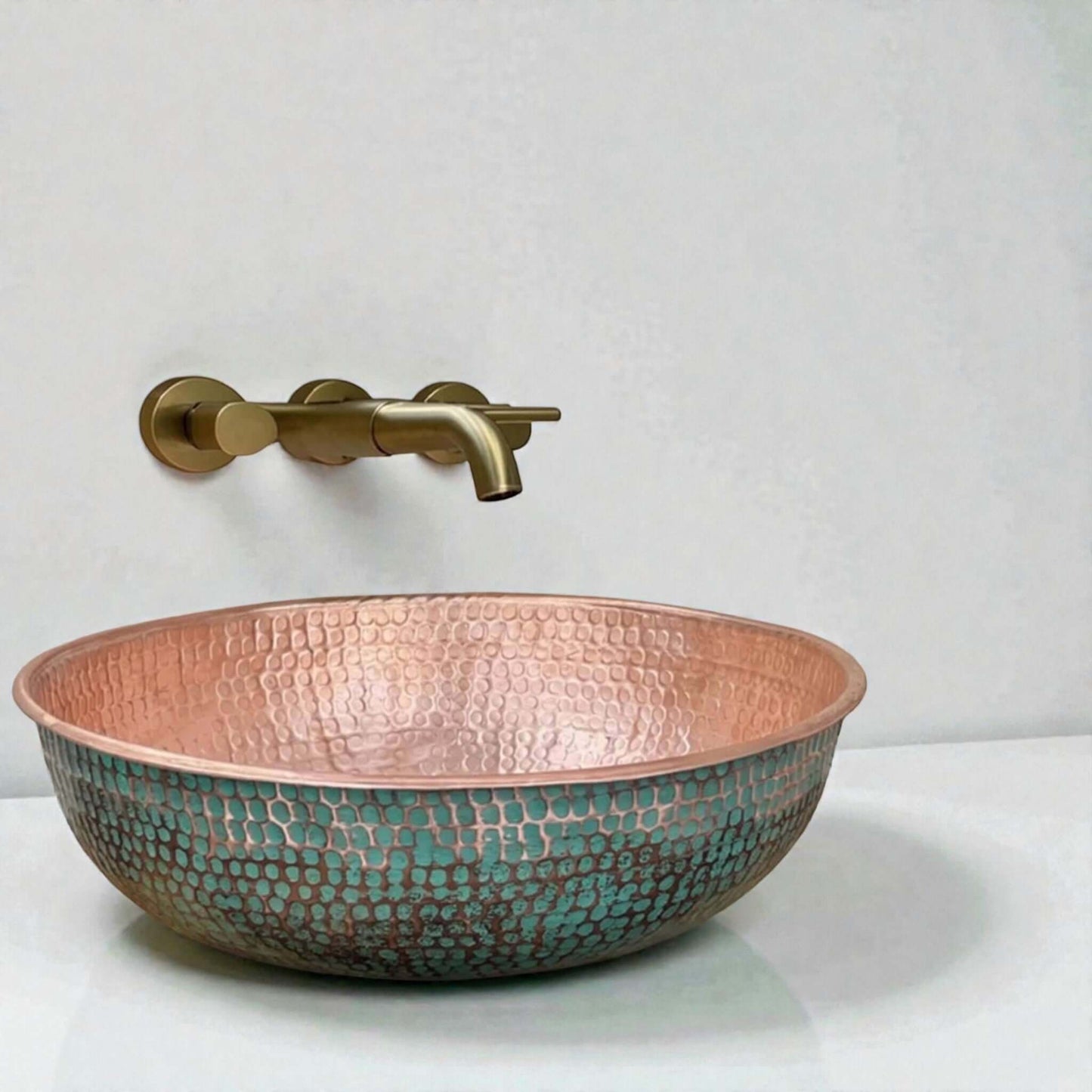 Green Patina Brass Vessel Sink displayed in a stylish bathroom with a round mirror and modern fixtures.
