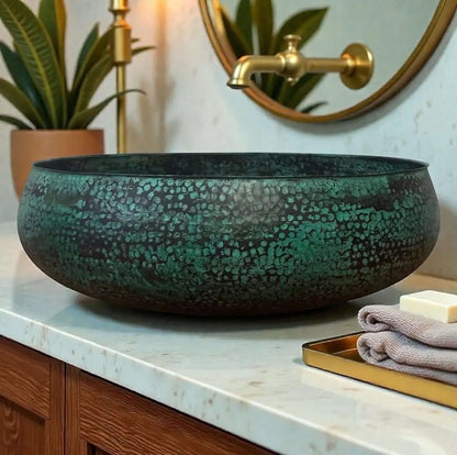 Bathroom vanity with a textured green sink, gold faucet, and decorative elements.
