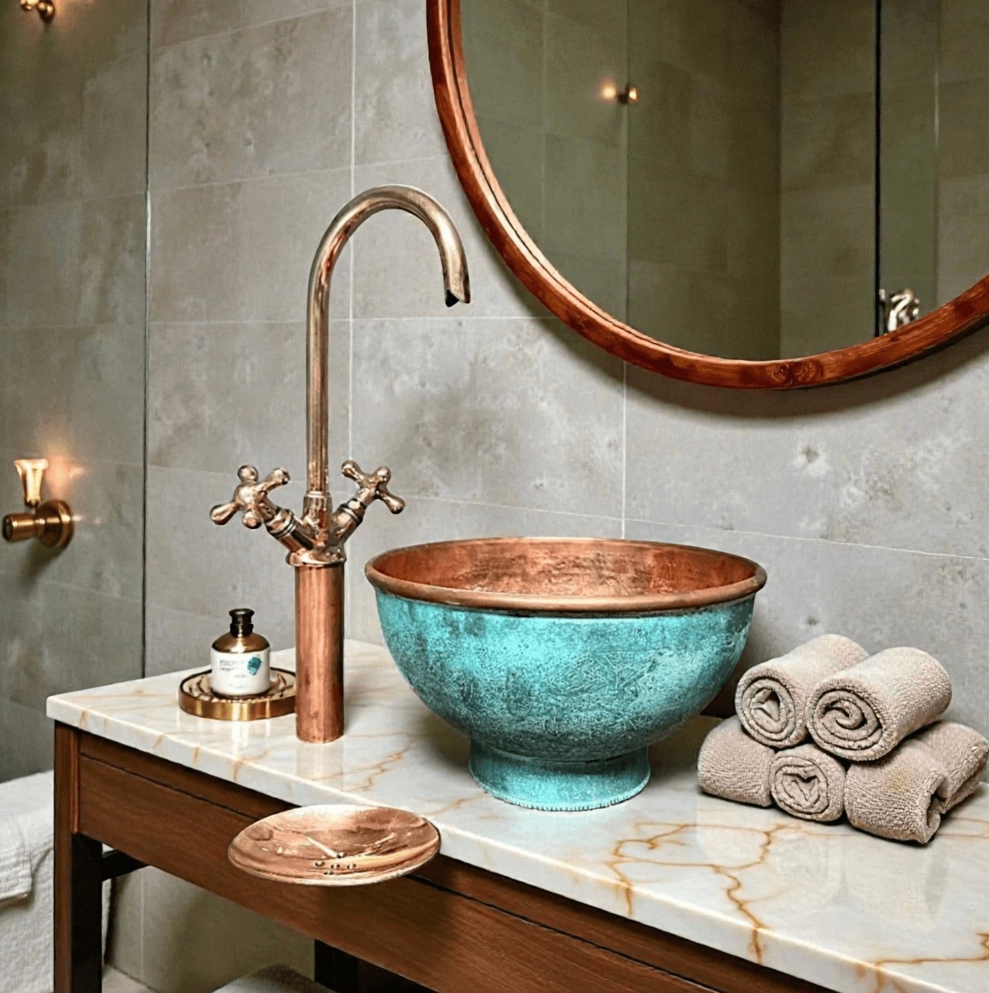 Pedestal green patina copper vessel sink with a stylish faucet and towels in an elegant bathroom setting.