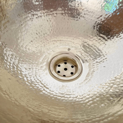 Close-up of a textured ceramic sink with a drain