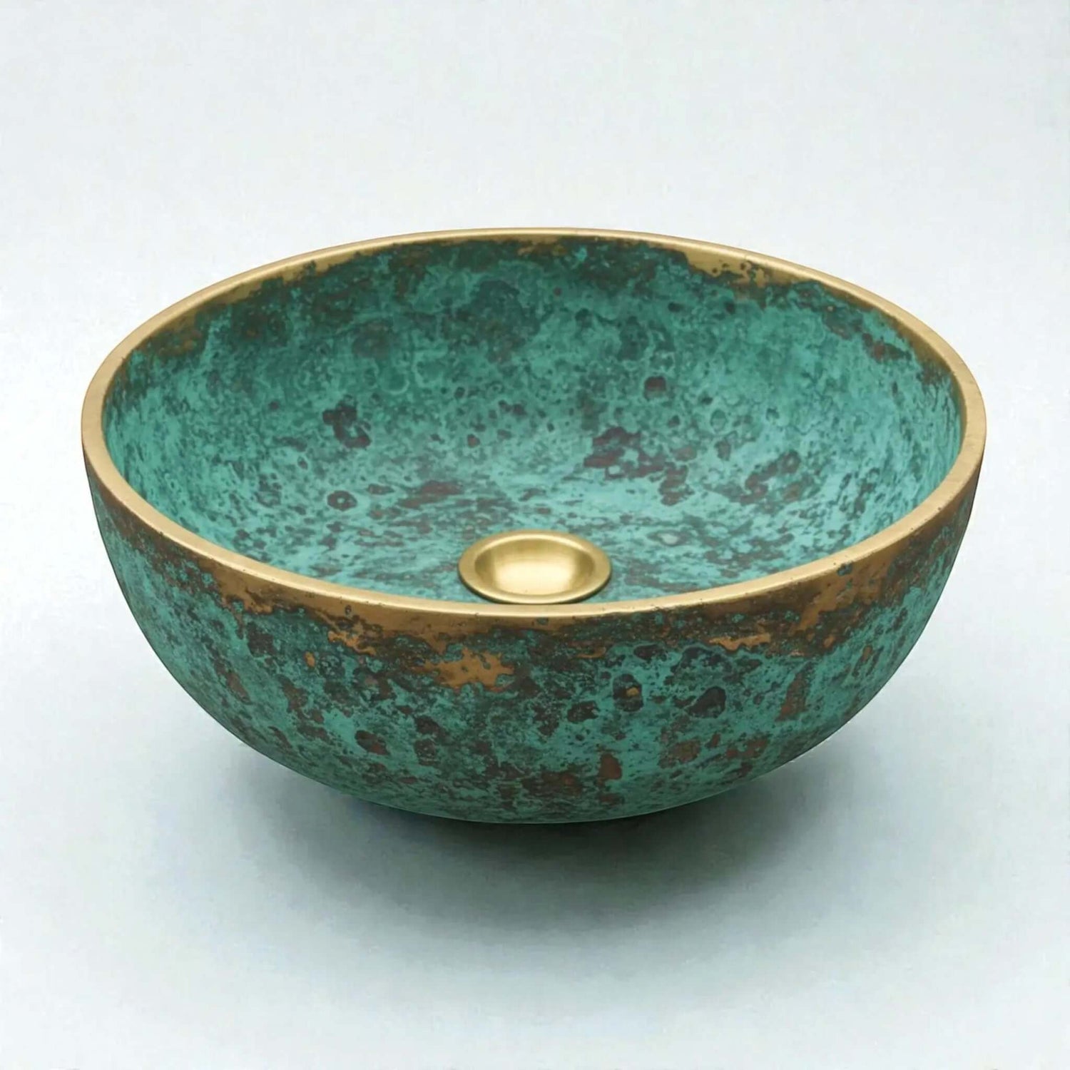 Decorative copper sink with a green and gold finish on a white background