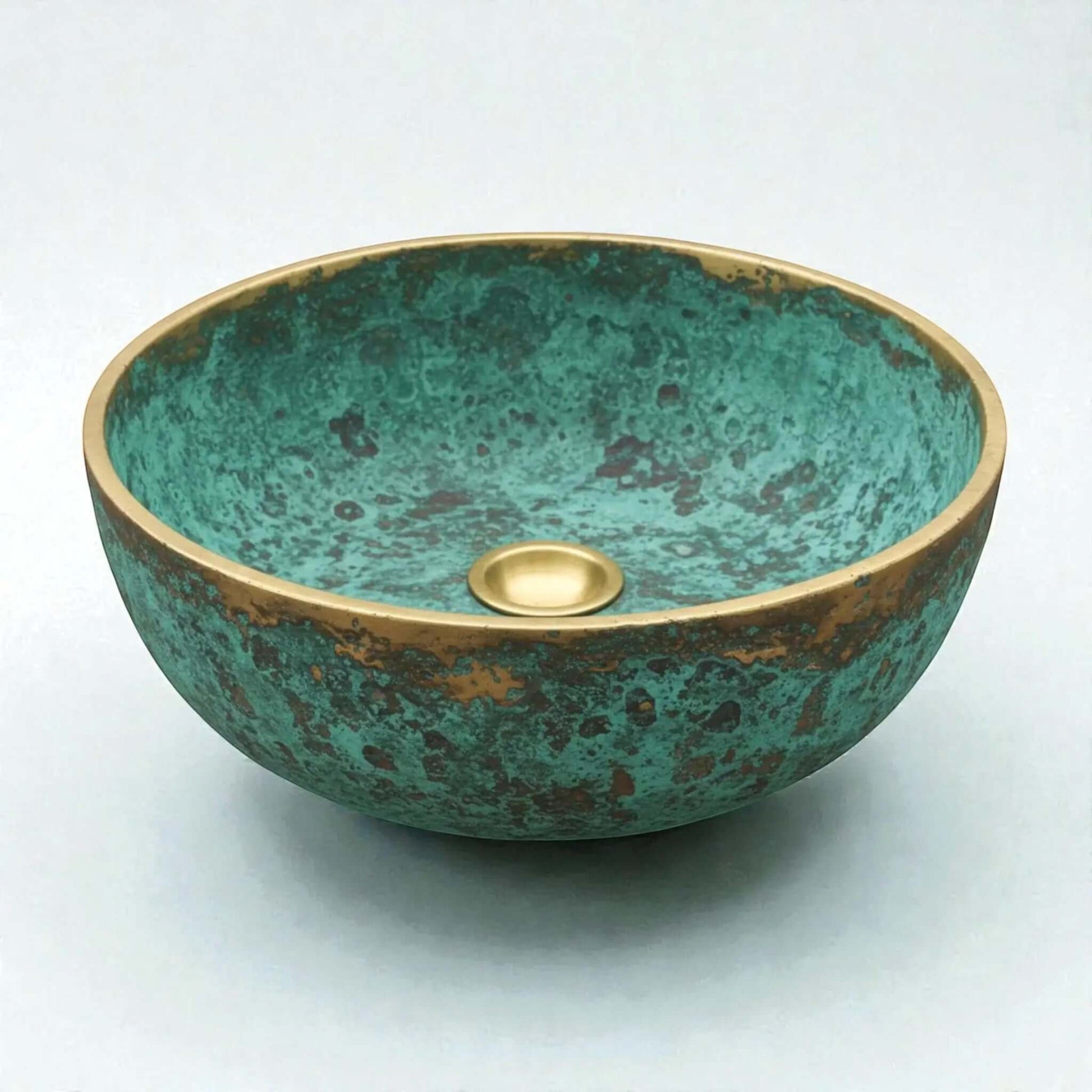 Decorative copper sink with a green and gold finish on a white background