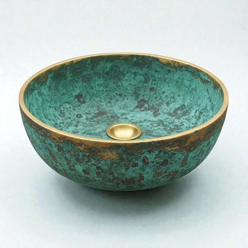 Decorative copper sink with a green and gold finish on a white background