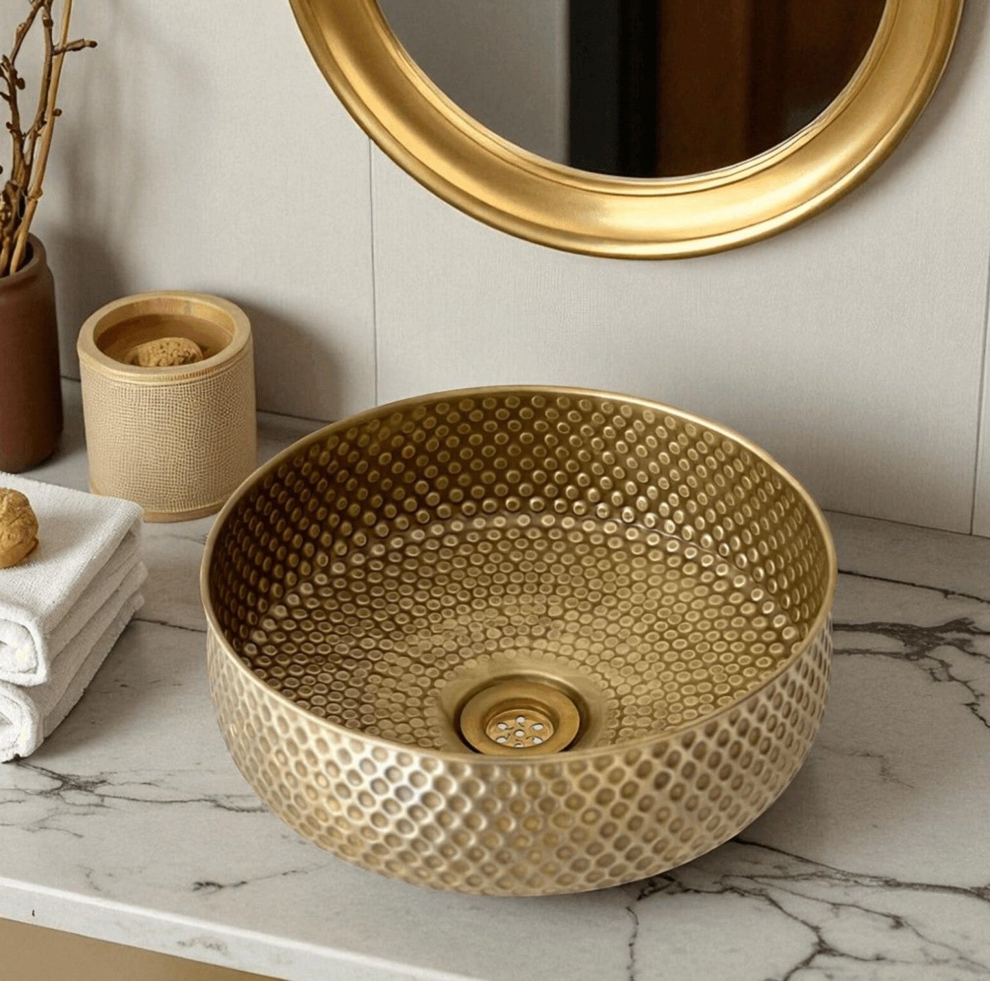 Oxidized copper vessel sink displayed in a stylish bathroom setting with a gold faucet and decor.
