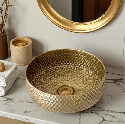 Oxidized copper vessel sink displayed in a stylish bathroom setting with a gold faucet and decor.