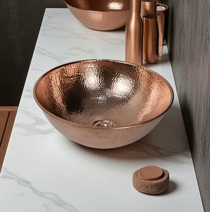 Coppera Studio hammered copper vessel sink with a polished rim, perfect for a rustic or modern bathroom.