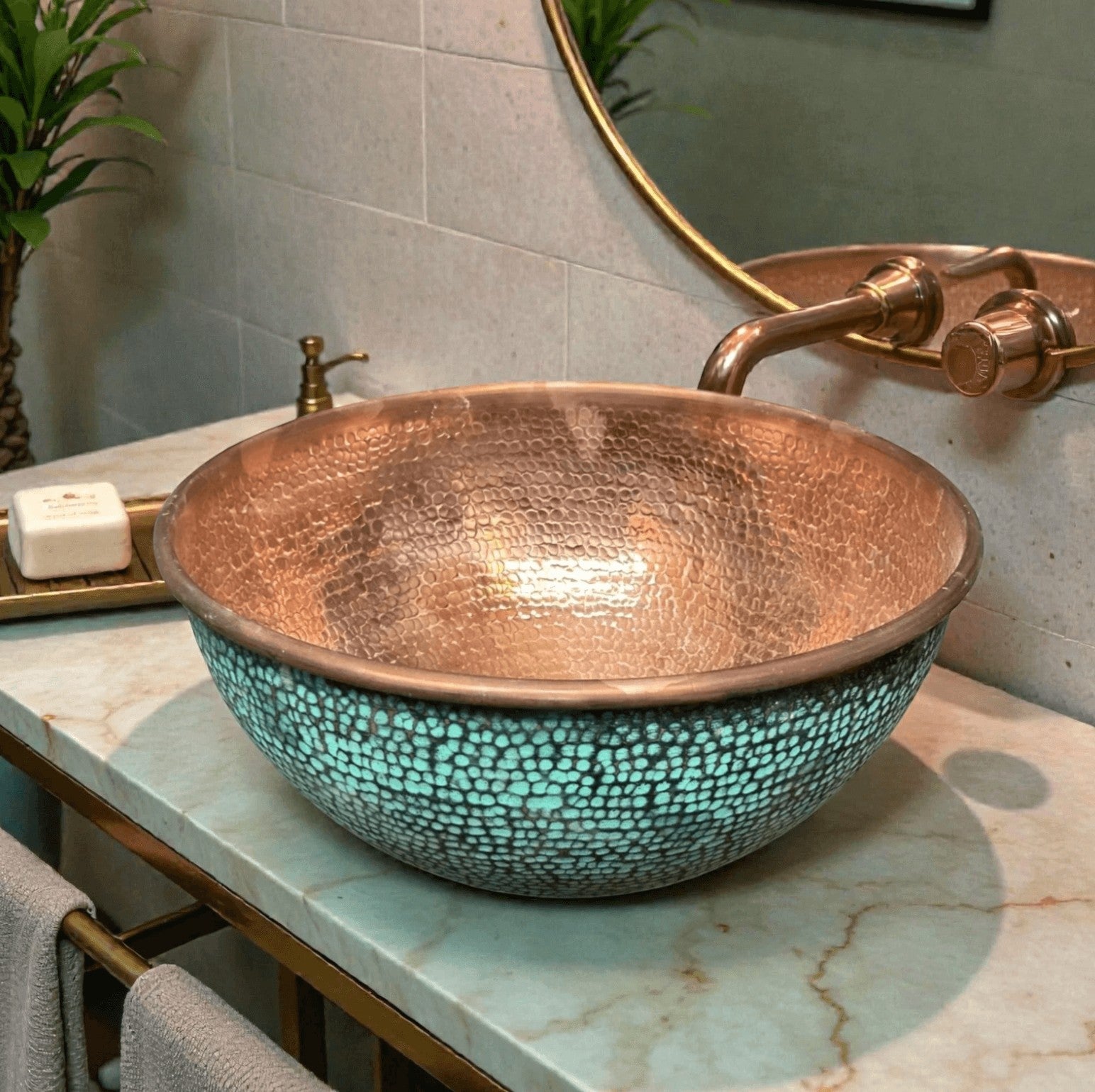 Handcrafted turquoise green patina copper vessel sink with gold rim accent on green marble countertop