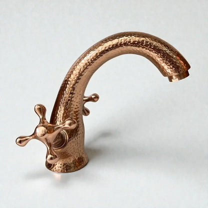 Copper faucet with a textured design on a light gray background