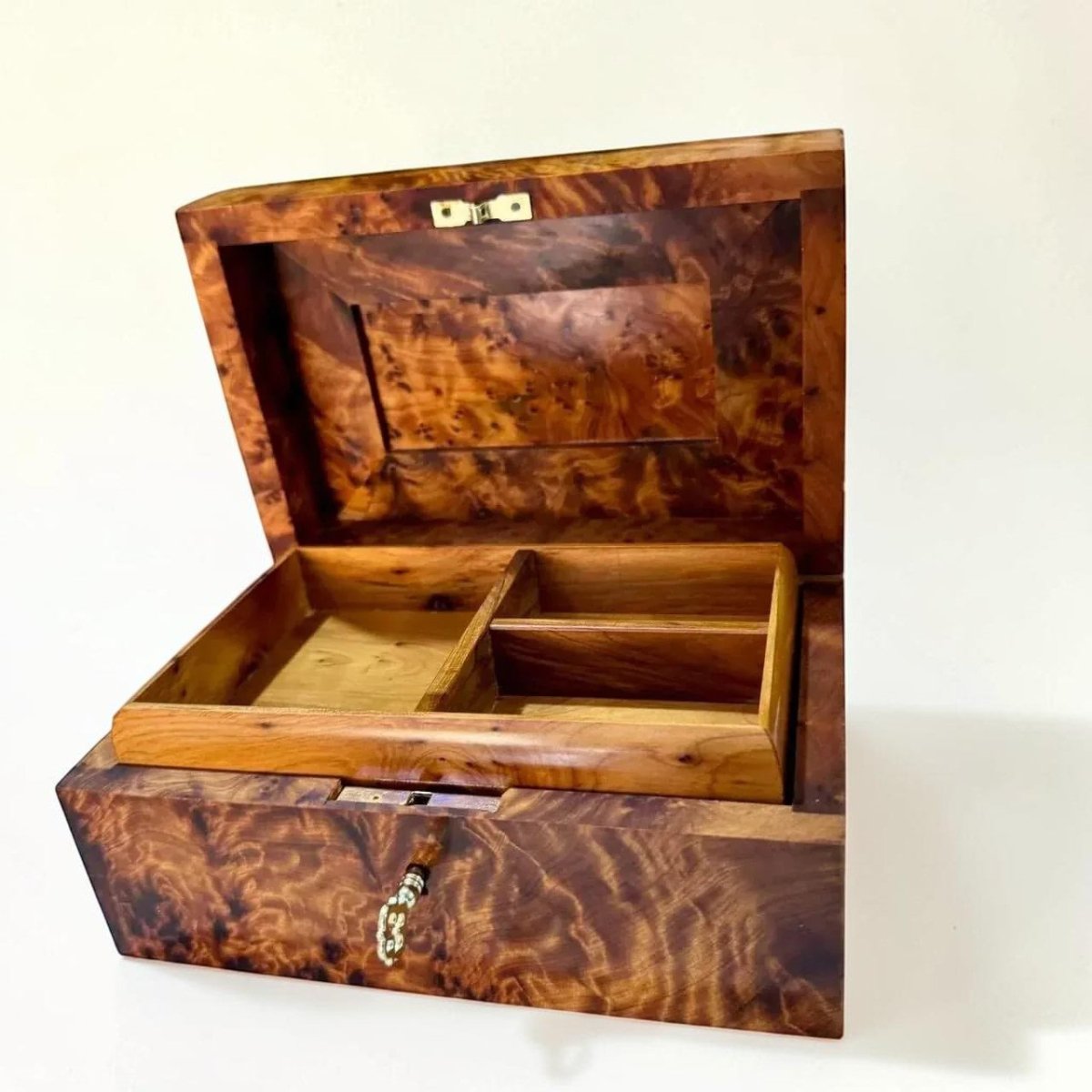 AtlasMuseCrafts handcrafted Thuya wood keepsake box with lockable lid and brass key. Features unique swirling grain patterns and interior compartments.