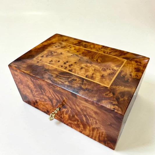 AtlasMuseCrafts handcrafted Thuya wood keepsake box with lockable lid and brass key. Features swirling grain patterns and a polished finish.