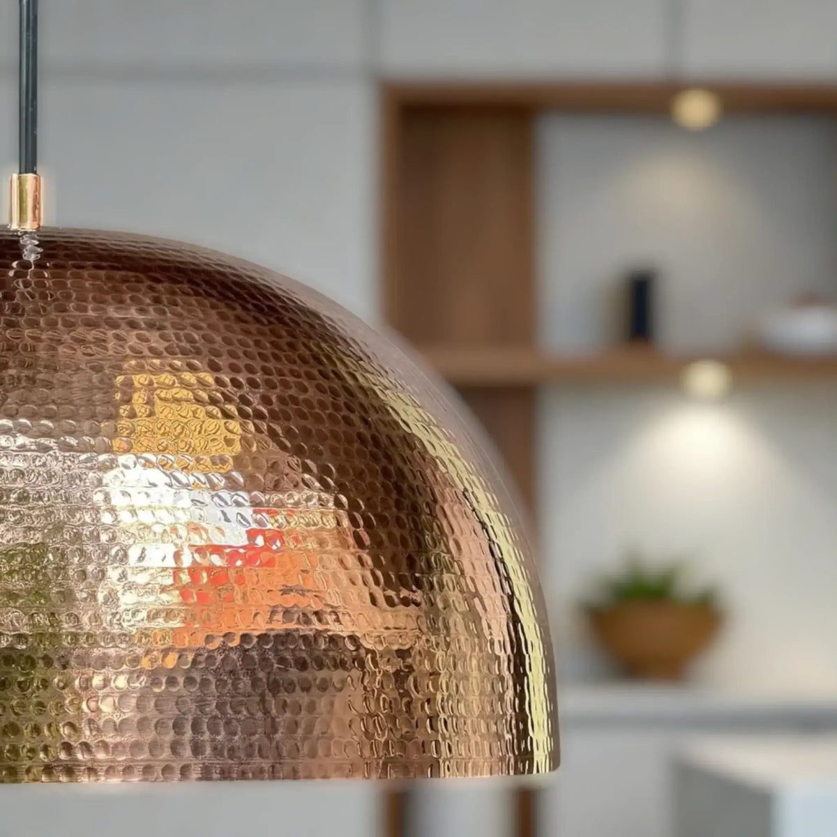Artisan copper pendant lamp with warm golden glow in kitchen
