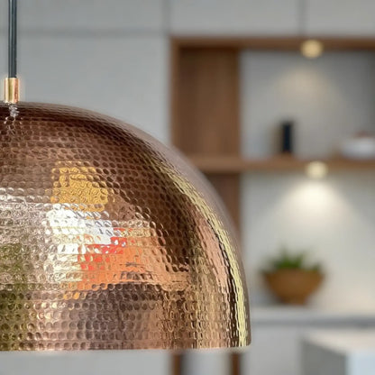 Artisan copper pendant lamp with warm golden glow in kitchen
