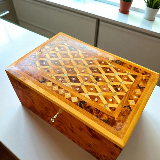 Wooden jewelry box with intricate lattice design on a light surface.