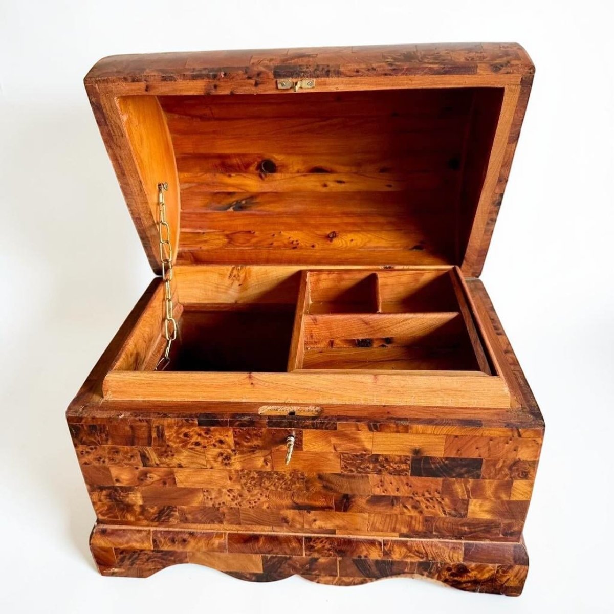 AtlasMuseCrafts handmade Thuya burl wooden box with coffer-style lid, brass lock, and interior compartments. Features unique burl grain patterns and warm wood tones.