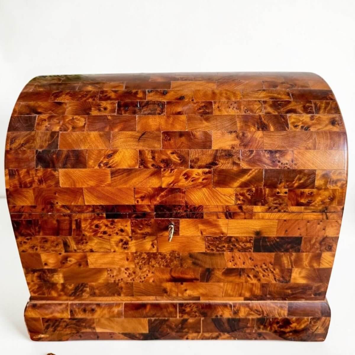 AtlasMuseCrafts handmade Thuya burl wood chest with coffer-style rounded design and brass key lock. Features unique swirling grain patterns and a warm, aromatic scent.