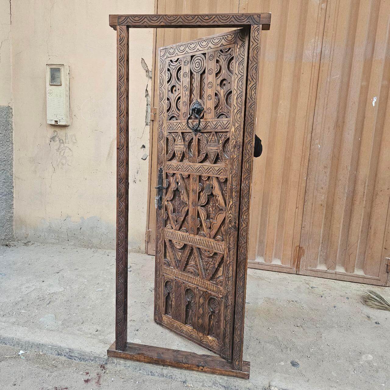 Aged natural wood single door with traditional carving