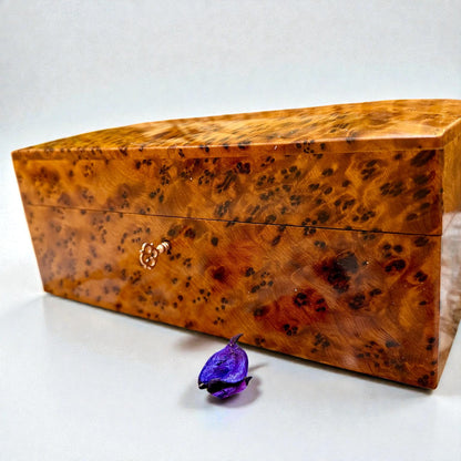 Wooden Box With Key made from Thuya burl with a small purple flower next to it.