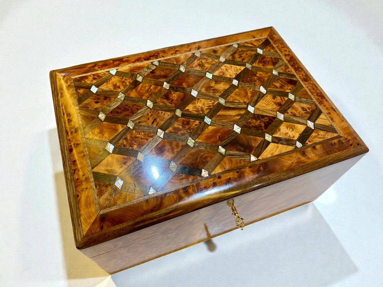 Wooden jewelry box with intricate inlay design on a white background