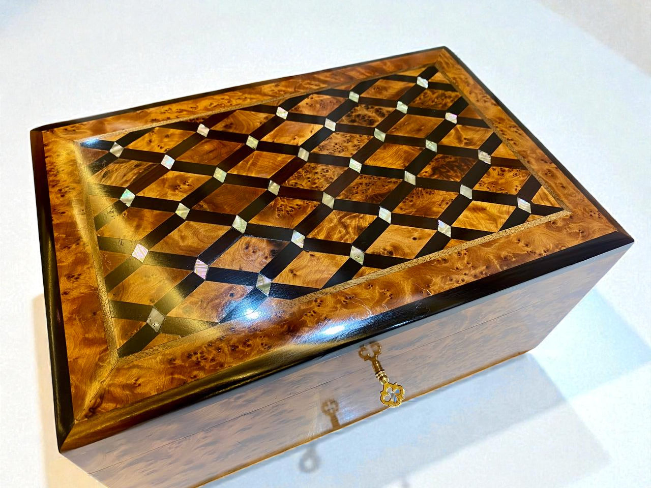 Wooden jewelry box with intricate inlay design on a white background