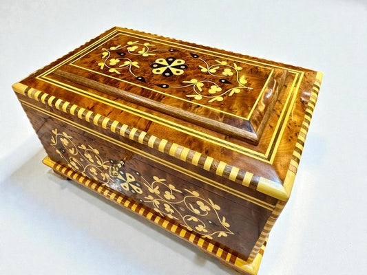 Wooden jewelry box with intricate inlay design on a white background