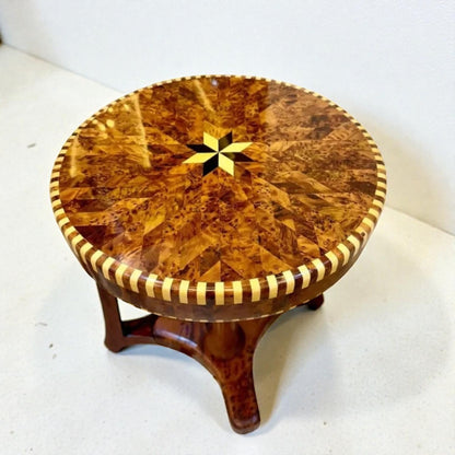 AtlasMuseCrafts handmade round Thuya wood coffee table with intricate starburst inlay and striped wood border.