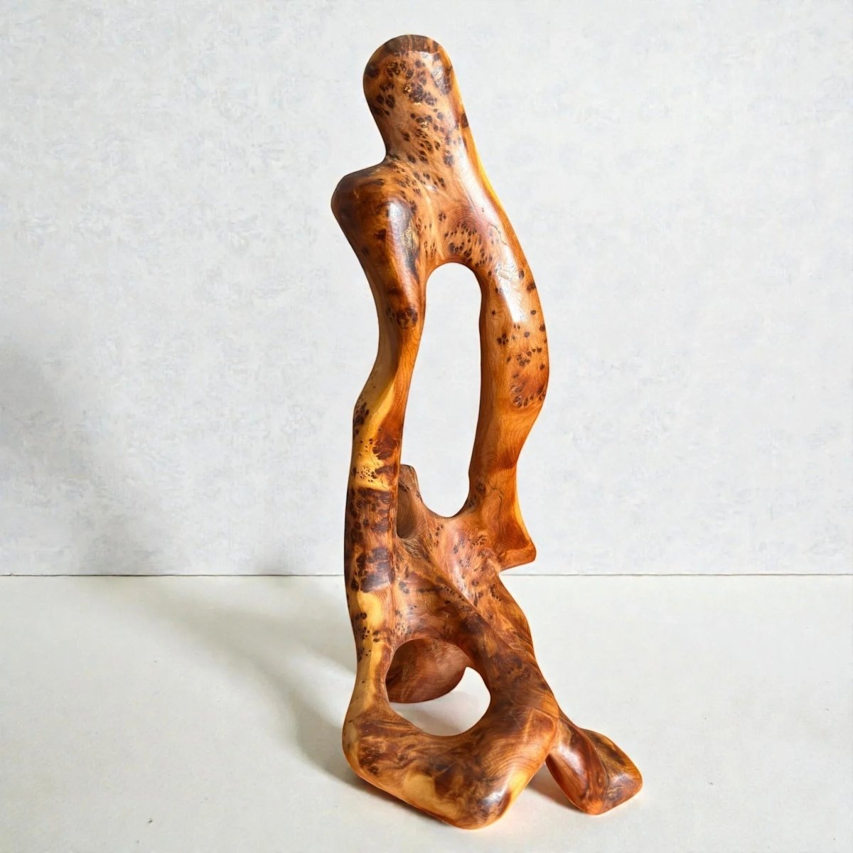 AtlasMuseCrafts abstract sculpture carved from natural Thuya wood, showcasing unique grain patterns and a warm golden-brown hue.
