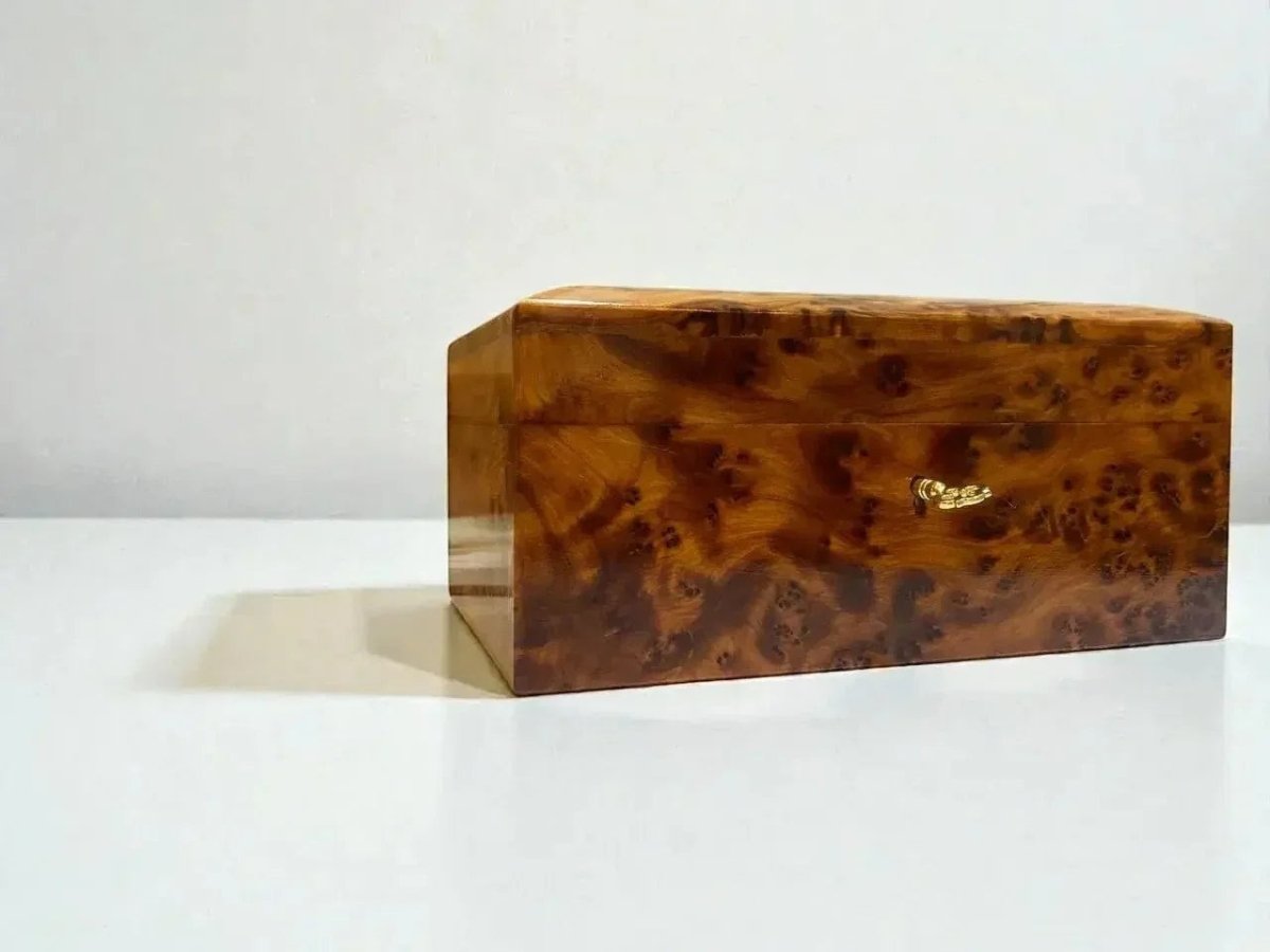AtlasMuseCrafts handmade Thuya wood jewelry box with swirling grain and gold clasp. Ideal for keepsakes, rings, and watches.