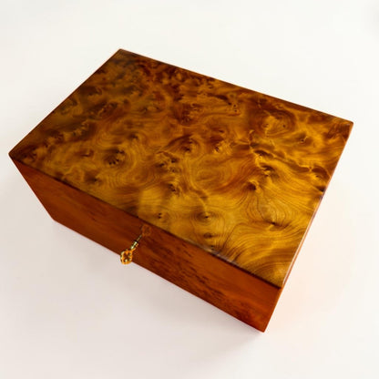 Thuya wood storage box with brass lock, key detail, and polished grain