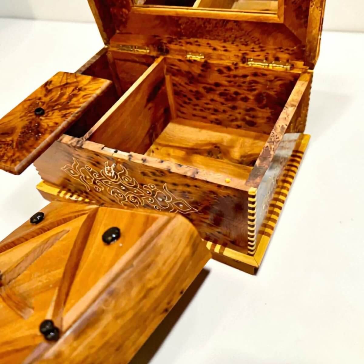 Crafted from Thuya burl wood, this Wooden Jewelry Box with Mirror features intricate detailing and compartments.